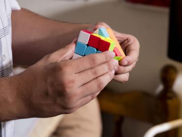 hands holding a colorful Rubik's cube
