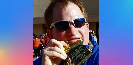 Andy wearing sunglasses and holding a metal for a 15k