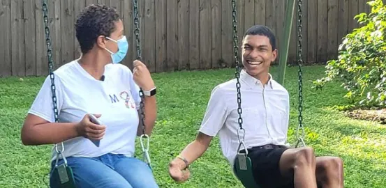 Blogger Michelle swinging on a swing set with her son, Justin. Justin has a big smile on his face.