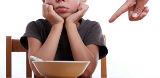 Child in front of a bowl of food that they don't want to eat