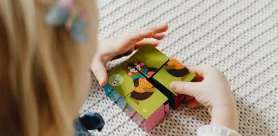 Child with blonde hair putting together blocks