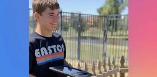 A boy with a shirt that says Easton and a iPad smiles off camera