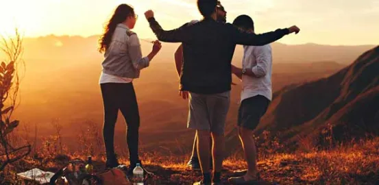 Group of teens hiking during sunset