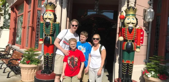 Jeff McCafferty, his wife and two sons in front of life size nut crackers