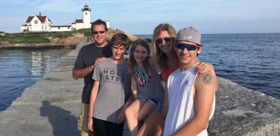 Kathy Hooven and her family in front of a lighthouse