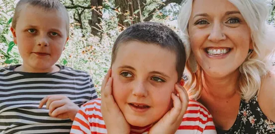 a blonde mother with her two sons wearing striped shirts