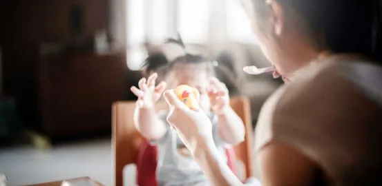 Mother feeding her young child