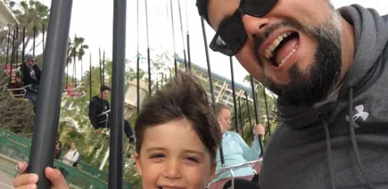 Nick Wright and his son on an amusement park ride