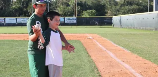 Two brothers stand to throw out the first pitch