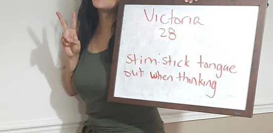 Victoria Handy holding a sign that describes how she stims