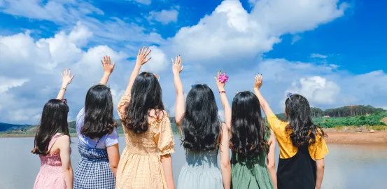a group of girls with long black hair and their arms in the air