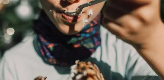 a child with cake on his face as he is eating