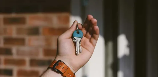 a mans hand holding up house keys