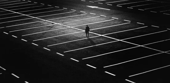 a person walking alone in an empty parking lot