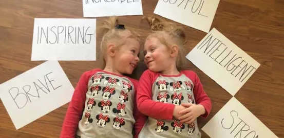 blonde toddlers laying on the floor wearing matching Minnie Mouse shirts