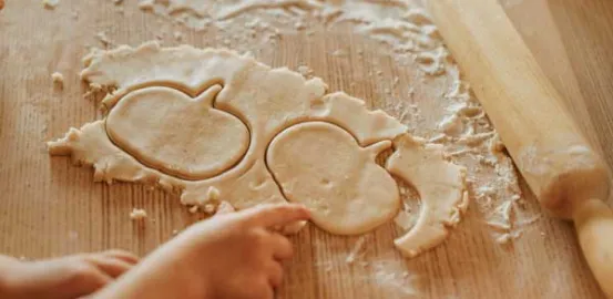 child making pumpkin shaped cookies