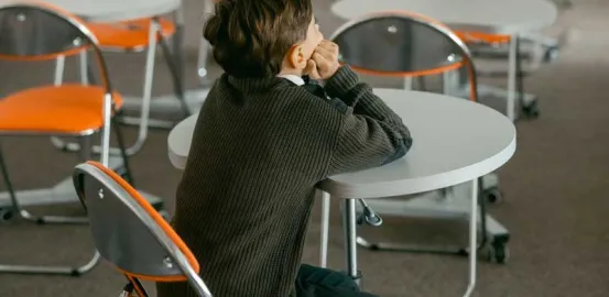 child sitting alone in an empty classroom