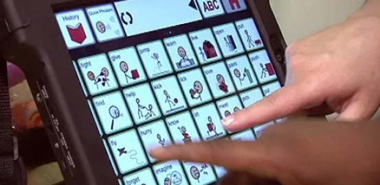 2 hands touching an iPad and using assistive technology to communicate