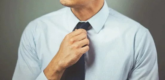 man adjusting his neck tie