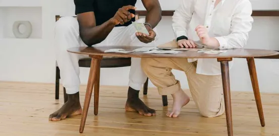 man and a child sitting at a wooden table playing cards