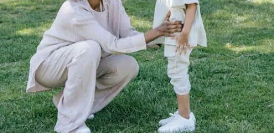 mother kneeling down to talk to her child outside