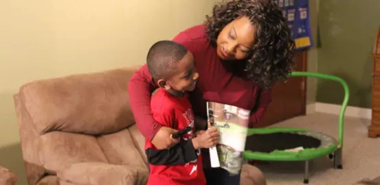 mother supportively hugging her son in their living room