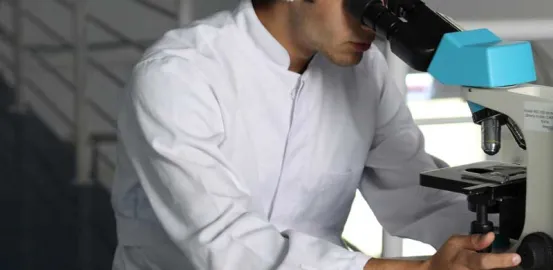 researcher using a microscope