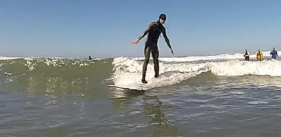 a man wearing a black wetsuit while surfing in the ocean
