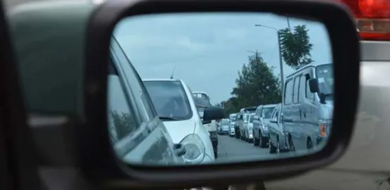 traffic on the highway in a rearview mirror