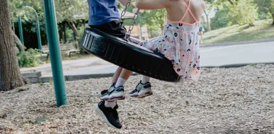 two children on a tire swing