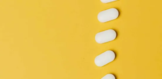 white pills on a yellow surface