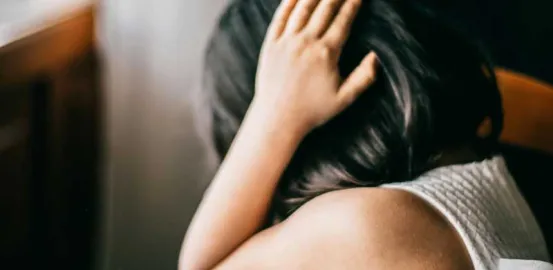 young girl anxiously covering her ears