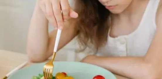 young girl eating a small salad