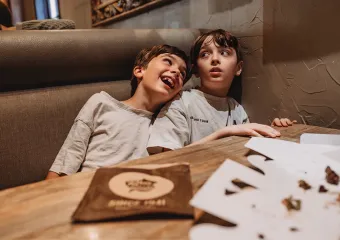 Eileen Lamb's children, Jude and Charlie sitting in a booth at a restaurant