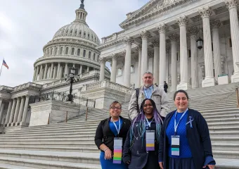 one male and three female advocates standing on the steps of the US Capitol with building dome in the background