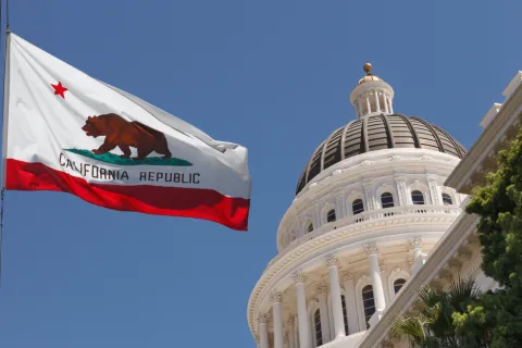 California state flag next to capitol dome