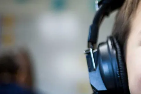 Child wearing headphones to help with auditory processing disorder