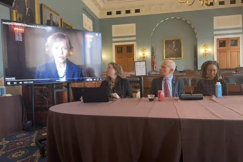 Three panelists watching TV for video of Former First Lady Rosalynn Carter speaking about caregivers