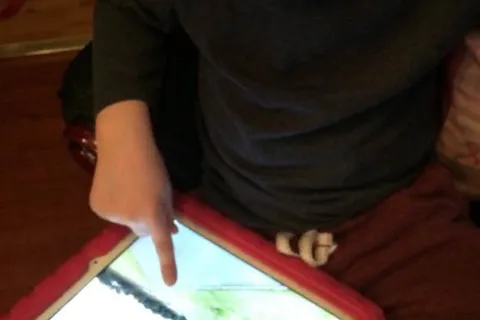 Isaac looking at Google Maps on an iPad