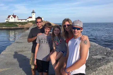 Kathy Hooven and her family in front of a lighthouse