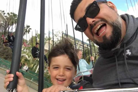 Nick Wright and his son on an amusement park ride