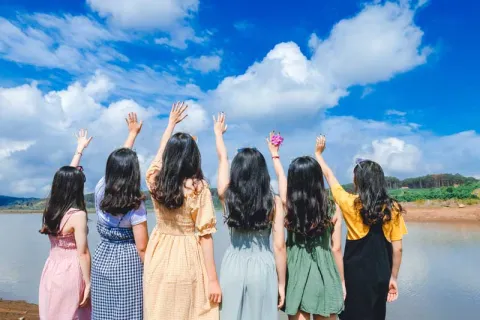 a group of girls with long black hair and their arms in the air