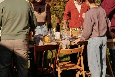 a group of people around an outdoor dining table