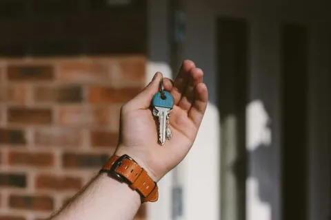 a mans hand holding up house keys