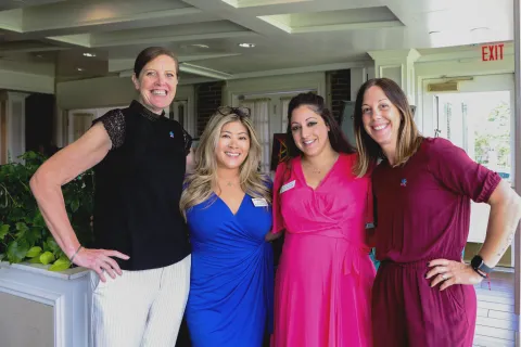 4 Autism Speaks staff posing for photo at an event