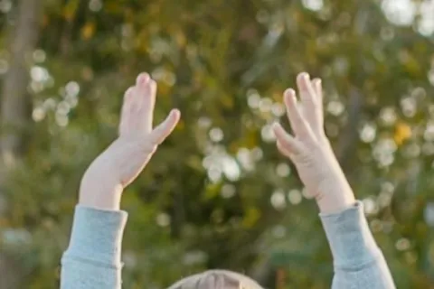 child moving and flapping hands in the air