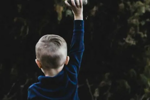 child outside throwing things