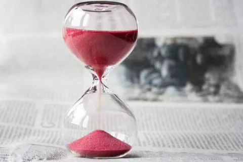 hourglass with red sand on a table