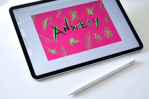 iPad with the paint app open to a design that says 'anxiety'