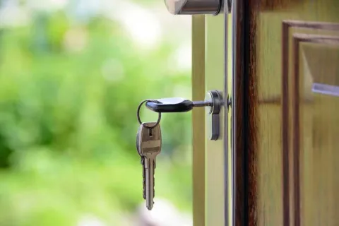 keys to a house hanging from the door knob